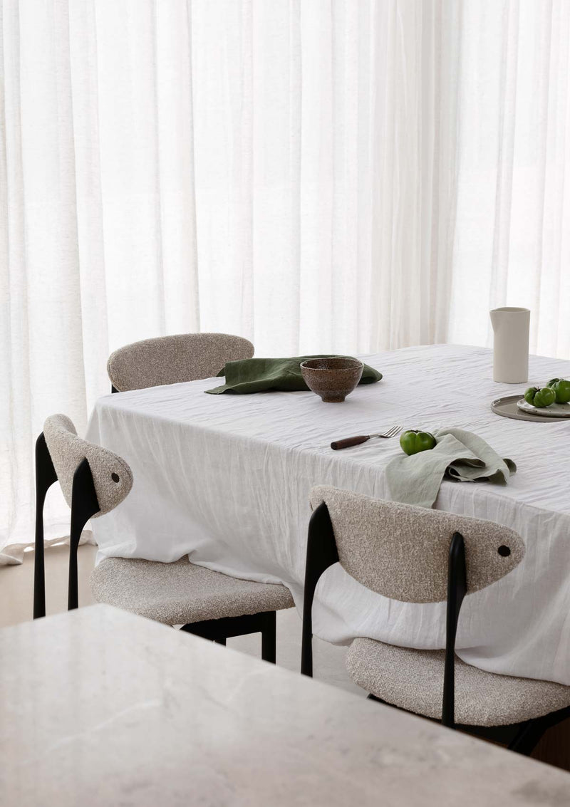 Table set with white linen tablecloth and forest green napkins.